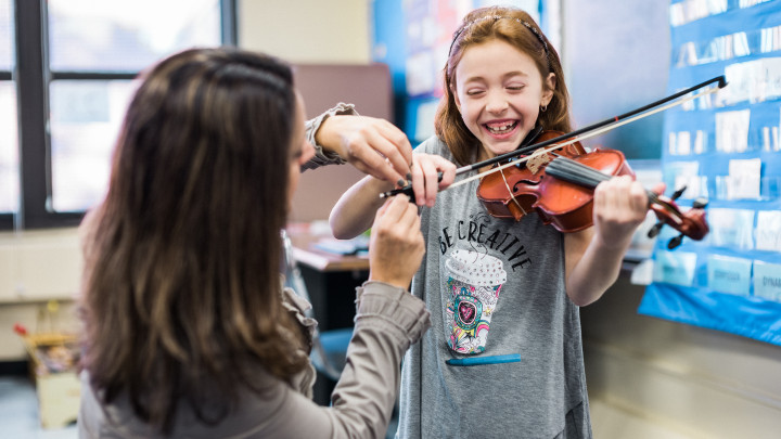 Image of girl playing the violin with teacher