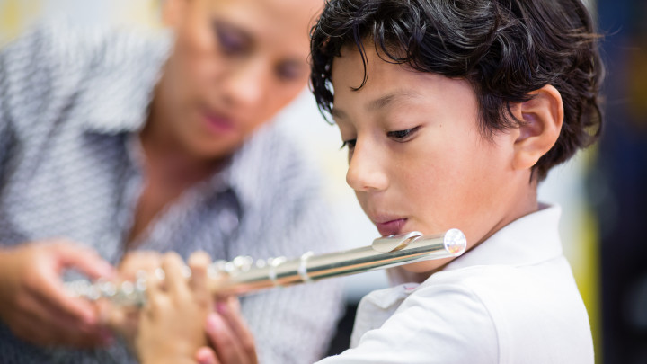 Music teacher helping student play flute