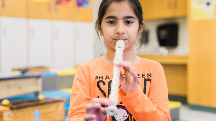 Elementary girl playing the recorder