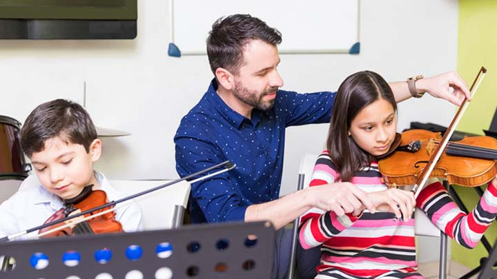 Teacher with kids playing the violin