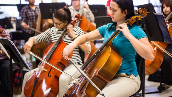 Image of high school students practicing cello in school