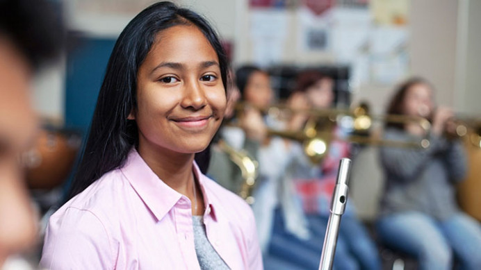 Student holds a flute during a school music program, reflecting The NAMM Foundation’s commitment to expanding access to music-making.